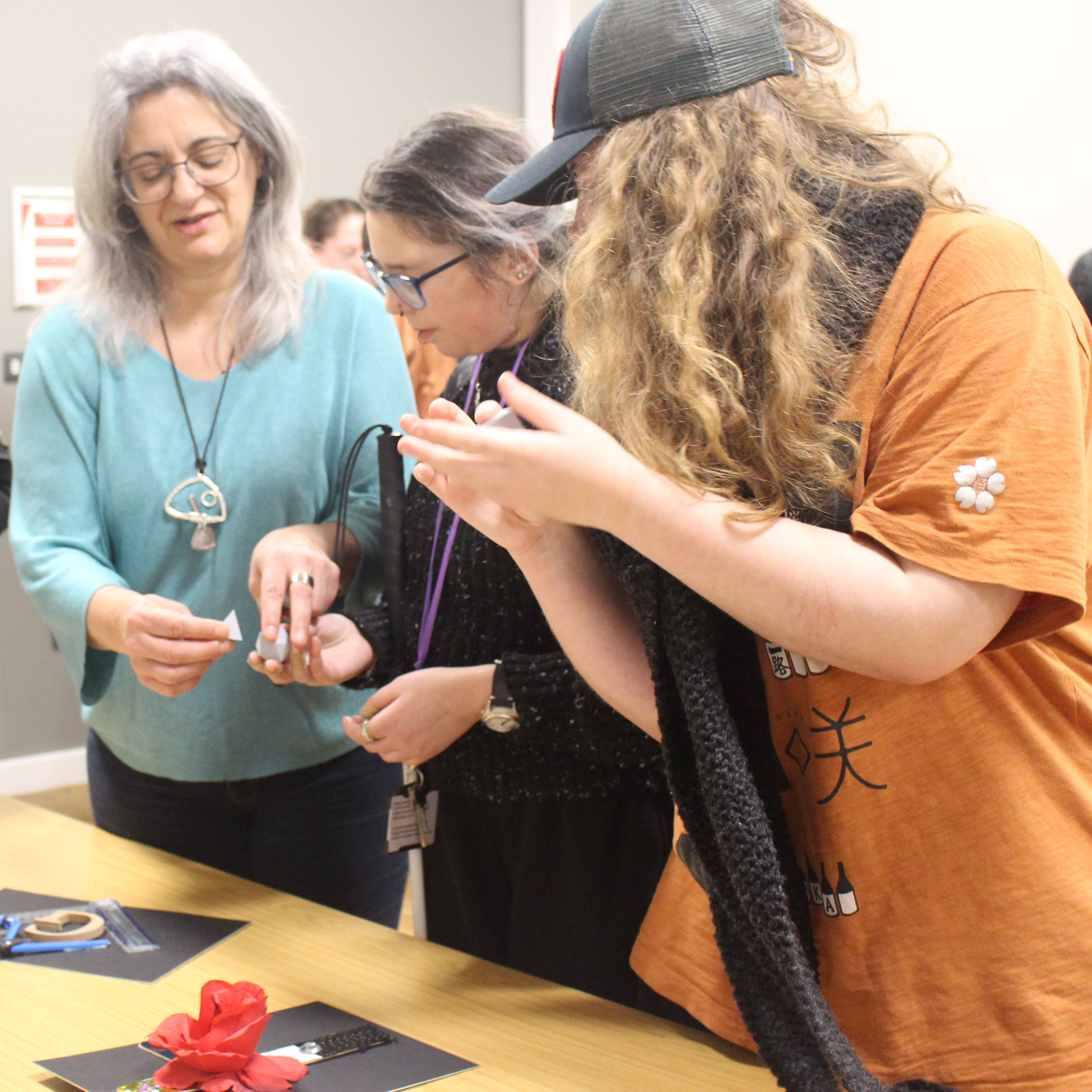 a volunteer and students hold 3-D shapes representing the symbolism of freemasonry