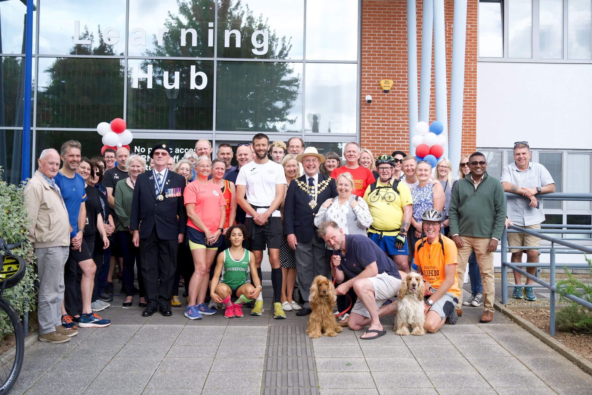 Darren stands with his welcoming committee in front of the College's Learning Hub