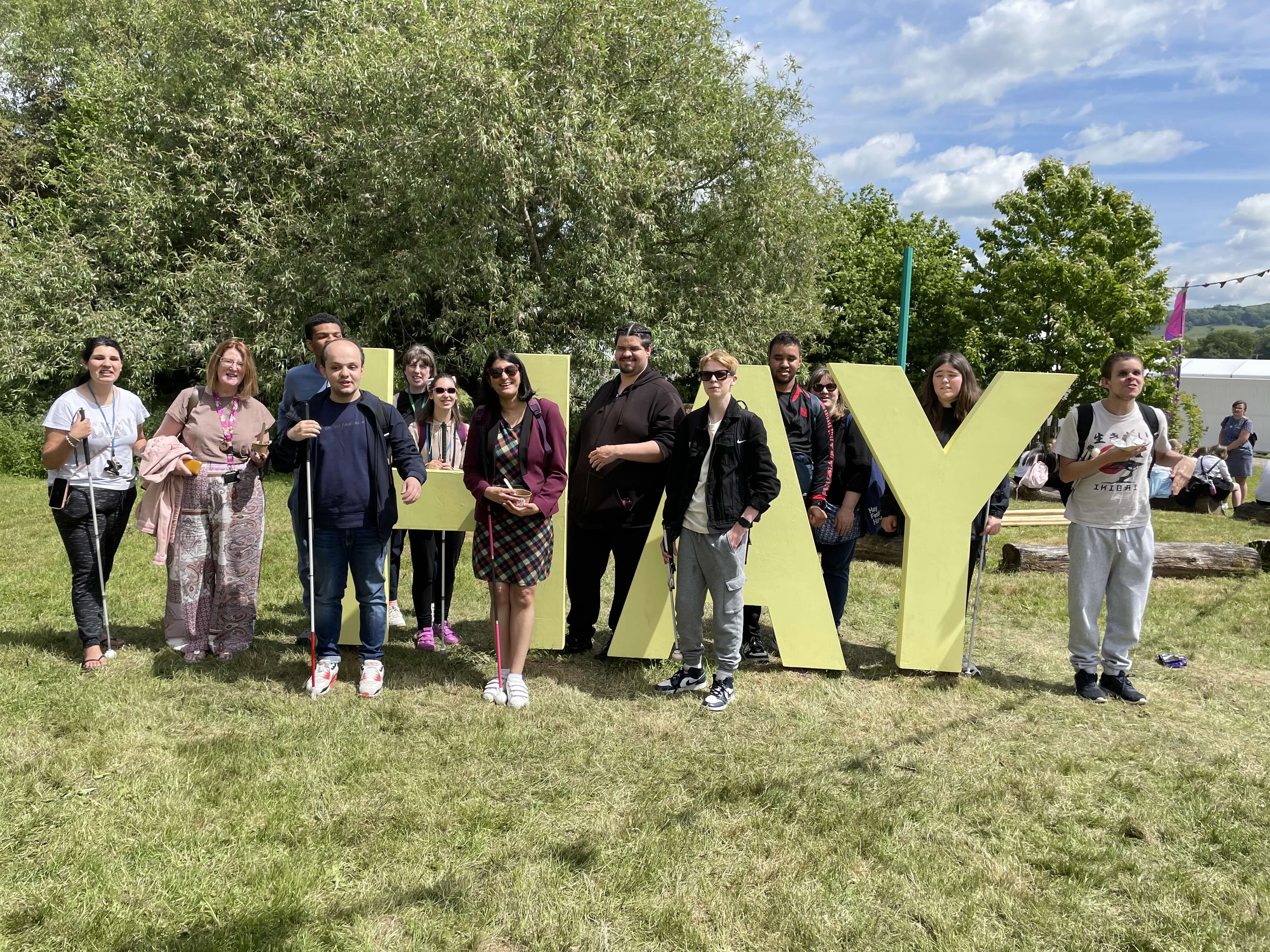 the group standing around the giant standing letters which spell out HAY