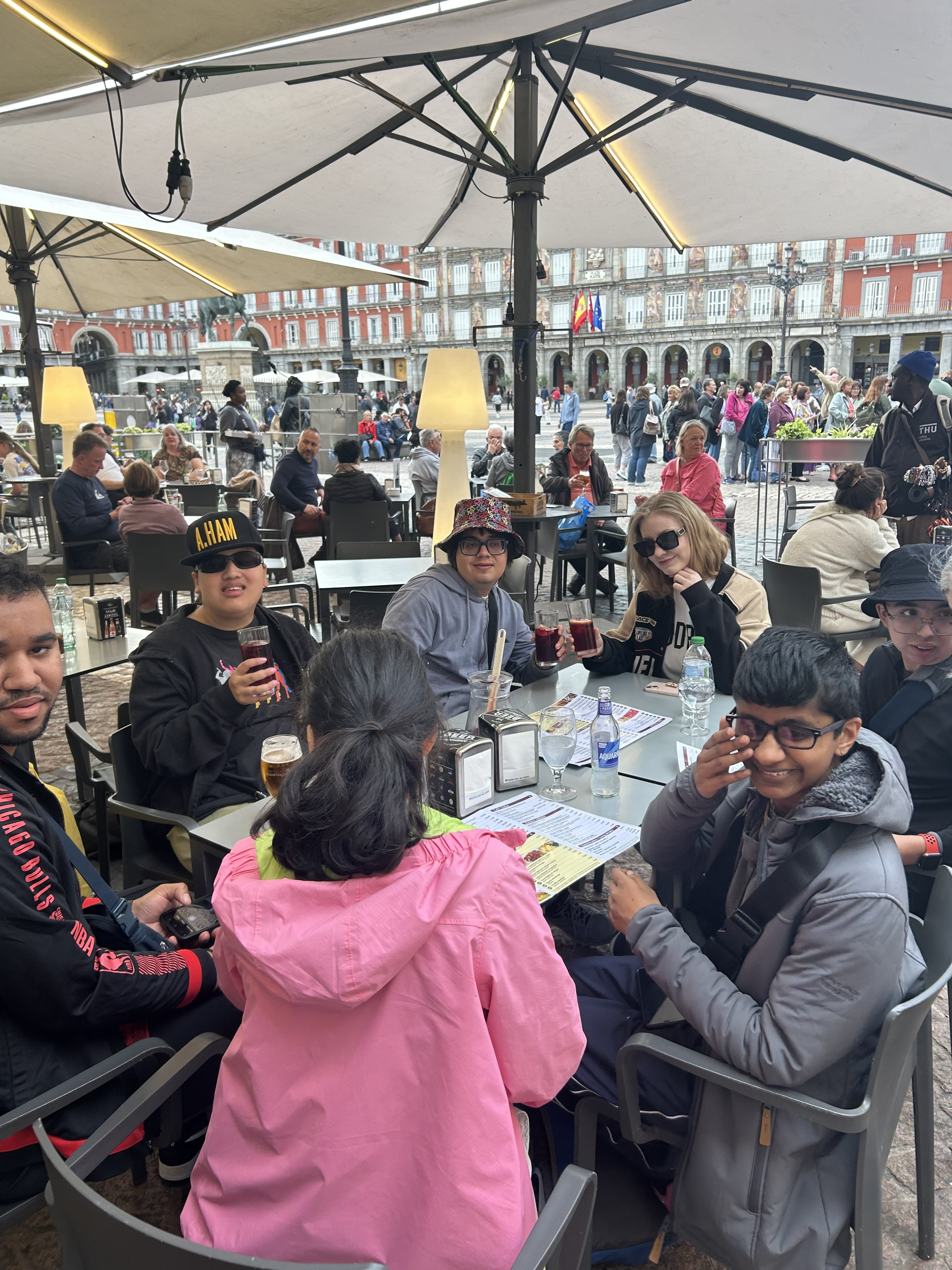 Grouped around a table with drinks waiting for lunch in a pavement cafe in Plaza Mayor