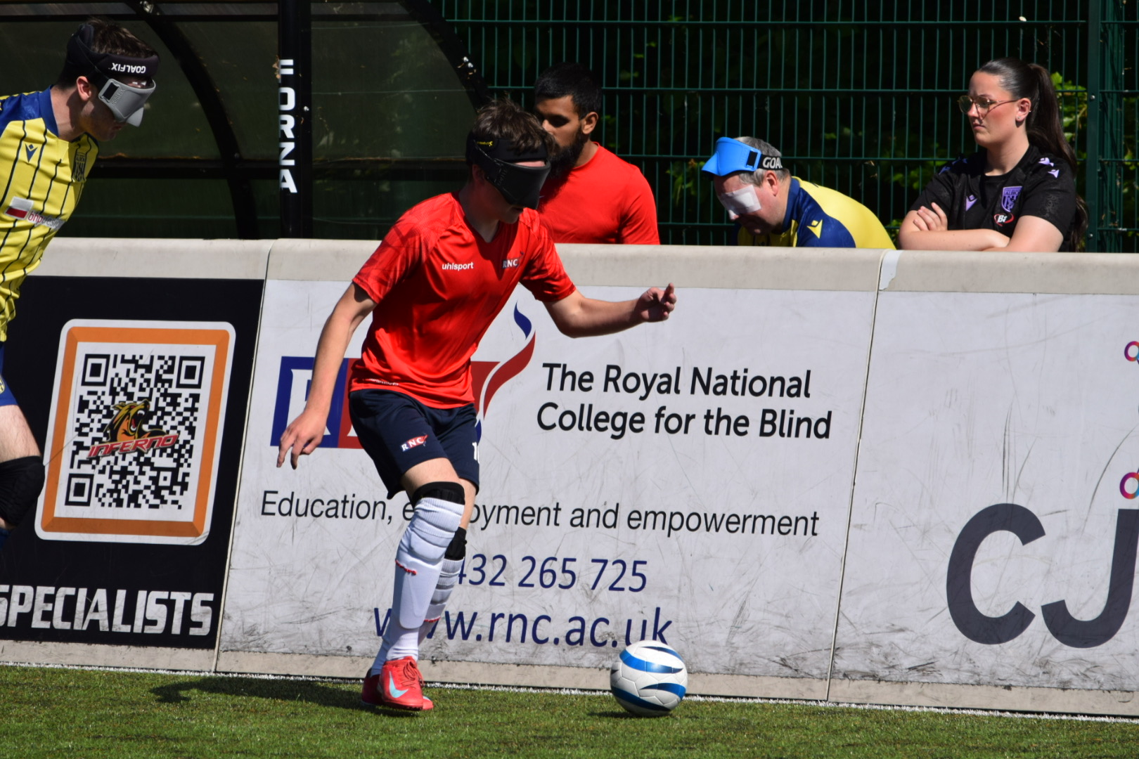RNC player on the ball against the boards with a WBA player behind him